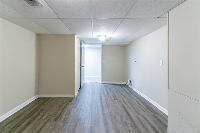 empty room with a drop ceiling and dark hardwood / wood-style floors