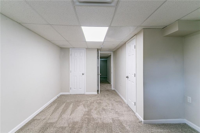 spare room with a drop ceiling and light colored carpet