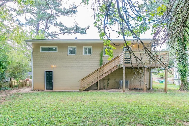 rear view of property featuring a lawn and central AC