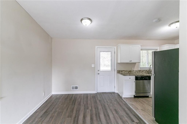 kitchen with dark stone counters, white cabinetry, hardwood / wood-style floors, and stainless steel appliances