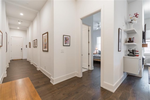 hall with dark wood finished floors, baseboards, plenty of natural light, and recessed lighting
