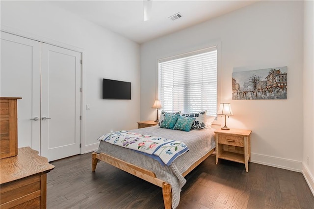 bedroom with visible vents, a closet, baseboards, and wood finished floors