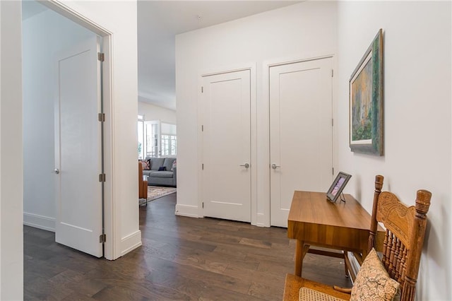 corridor featuring dark wood finished floors and baseboards