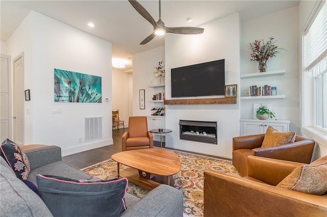 living area featuring visible vents, a fireplace, wood finished floors, recessed lighting, and a ceiling fan