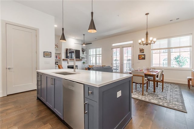 kitchen featuring light countertops, a sink, dishwasher, dark wood-style floors, and gray cabinetry