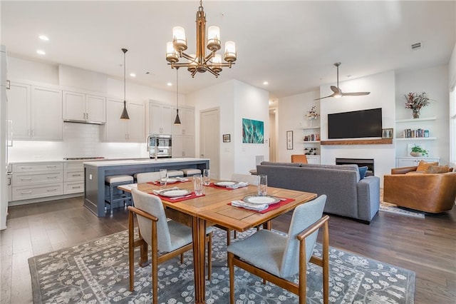dining area featuring dark wood-type flooring, a fireplace, visible vents, and recessed lighting