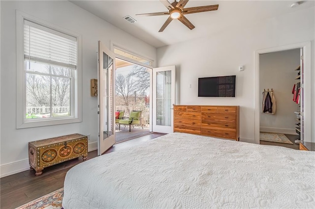 bedroom featuring visible vents, baseboards, wood finished floors, a ceiling fan, and access to exterior