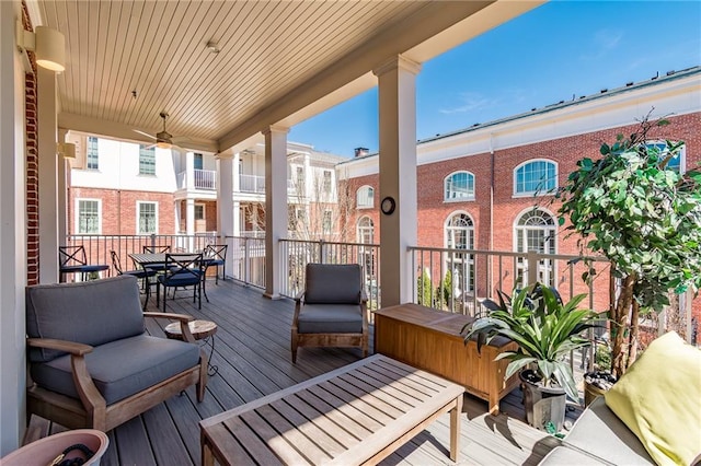 wooden deck with outdoor lounge area and a ceiling fan