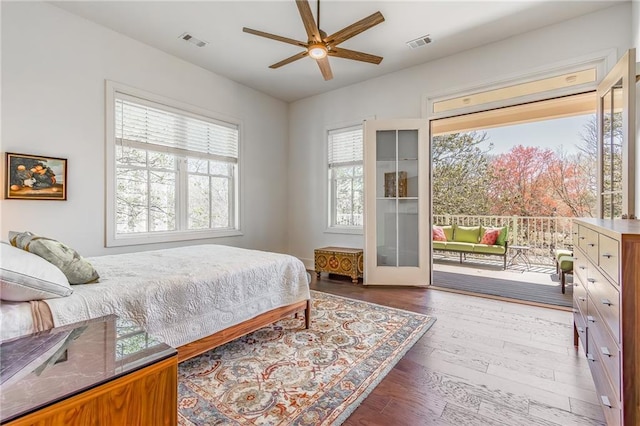 bedroom featuring access to exterior, visible vents, a ceiling fan, and wood finished floors