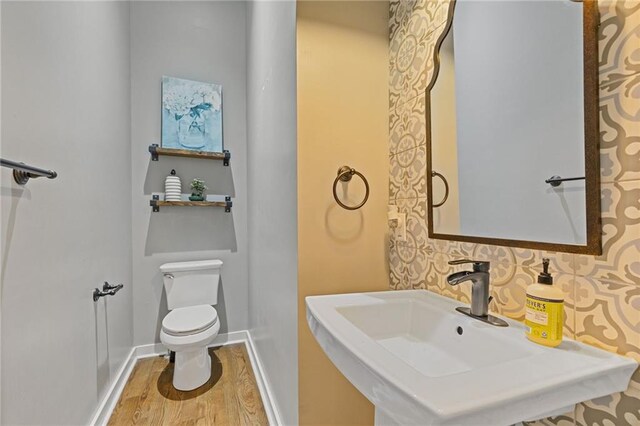 459 James P Brawley Dr NW, Atlanta, GA 30318 - bathroom featuring baseboards, a sink, toilet, and wood finished floors