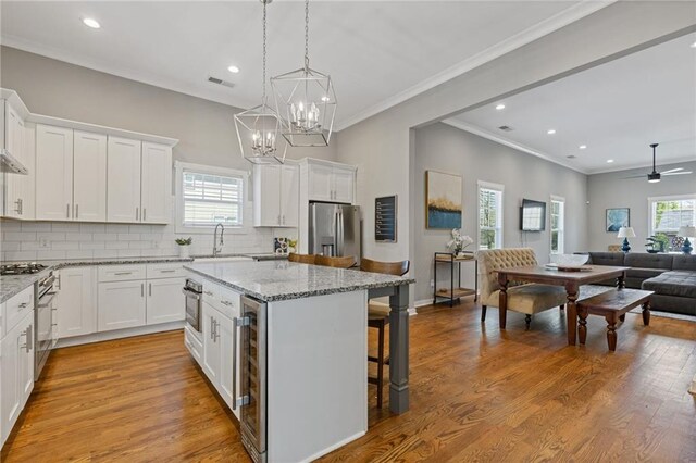 459 James P Brawley Dr NW, Atlanta, GA 30318 - kitchen with wine cooler, a kitchen island, appliances with stainless steel finishes, open floor plan, and a kitchen breakfast bar