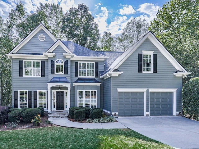 view of property with a garage and a front lawn