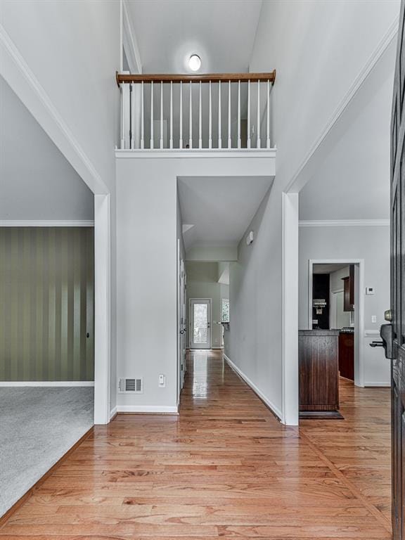 foyer featuring crown molding and light hardwood / wood-style flooring