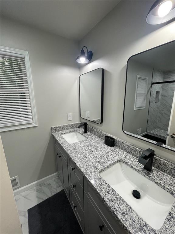 2166 Lake Ridge Ter, Lawrenceville, GA 30043 - full bathroom with a shower with shower door, double vanity, marble finish flooring, and baseboards
