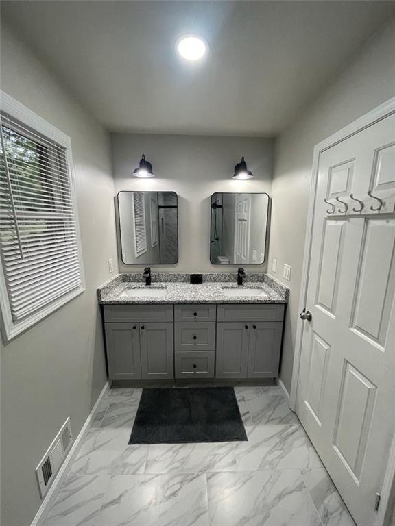 2166 Lake Ridge Ter, Lawrenceville, GA 30043 - bathroom with marble look tiles, double vanity, and baseboards