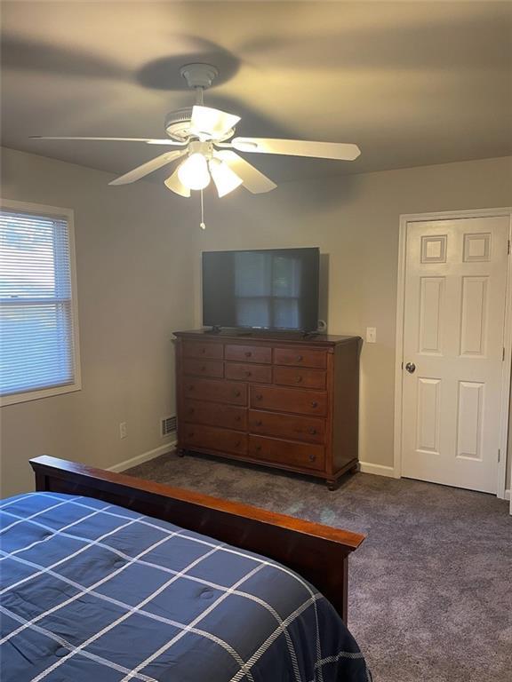 2166 Lake Ridge Ter, Lawrenceville, GA 30043 - bedroom featuring dark colored carpet, baseboards, and a ceiling fan