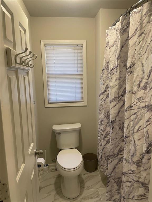 2166 Lake Ridge Ter, Lawrenceville, GA 30043 - bathroom featuring marble look tile flooring, toilet, and curtained shower