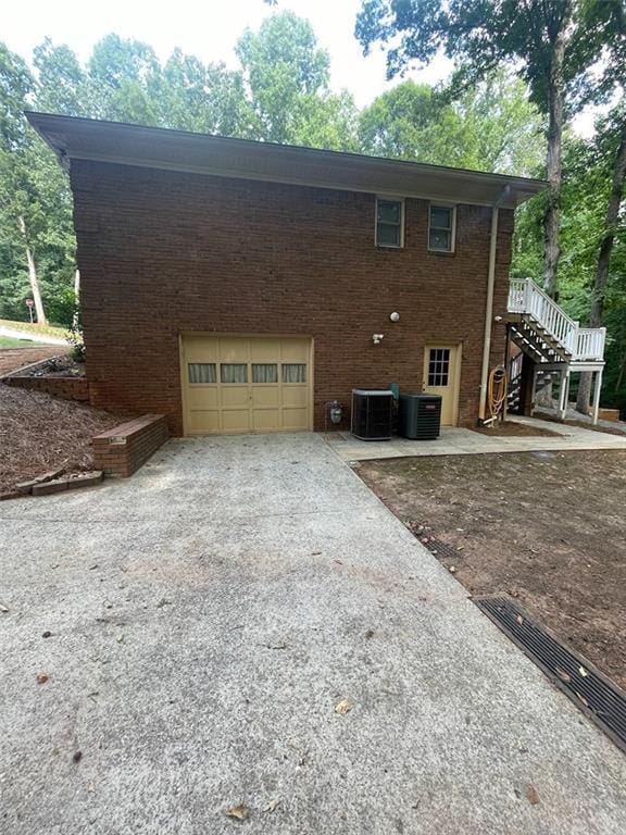 2166 Lake Ridge Ter, Lawrenceville, GA 30043 - view of side of home with driveway, cooling unit, a garage, and brick siding