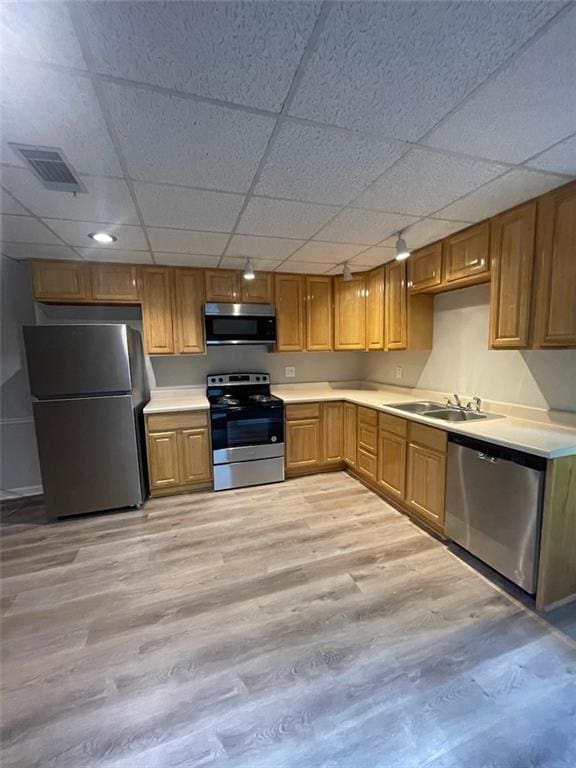 2166 Lake Ridge Ter, Lawrenceville, GA 30043 - kitchen featuring stainless steel appliances, a drop ceiling, light countertops, a sink, and light wood-style flooring