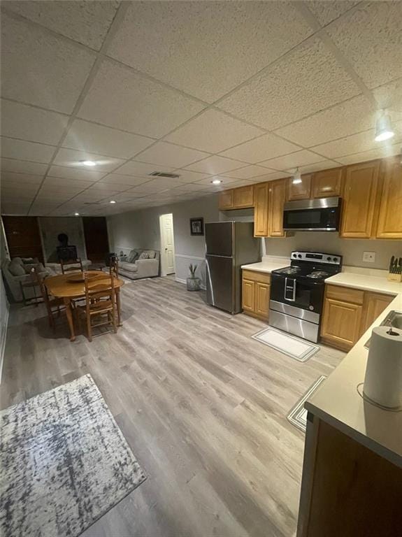 2166 Lake Ridge Ter, Lawrenceville, GA 30043 - kitchen featuring appliances with stainless steel finishes, light wood-style floors, a drop ceiling, open floor plan, and light countertops
