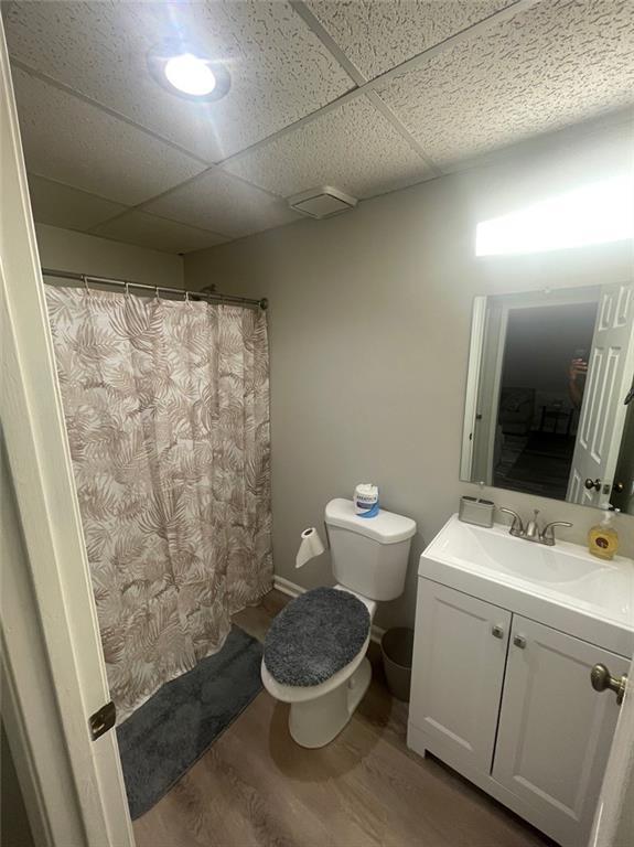 2166 Lake Ridge Ter, Lawrenceville, GA 30043 - full bathroom with toilet, vanity, wood finished floors, a drop ceiling, and a shower with curtain