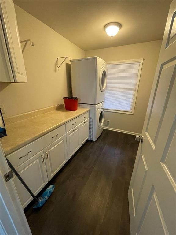 2166 Lake Ridge Ter, Lawrenceville, GA 30043 - laundry room featuring estacked washer and dryer, cabinet space, and dark wood-style floors