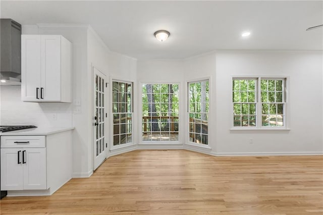 unfurnished dining area with crown molding and light hardwood / wood-style flooring