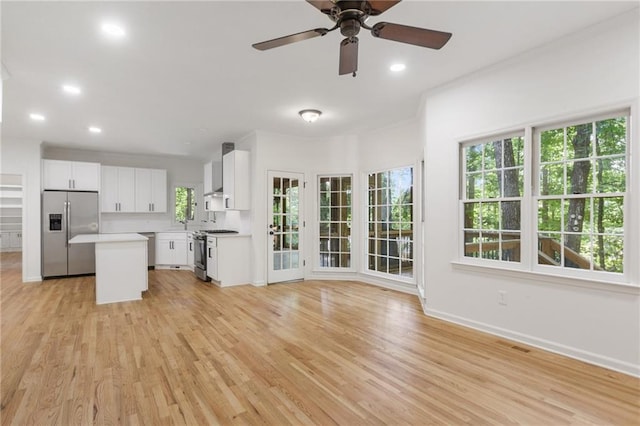 kitchen featuring a center island, light wood-type flooring, white cabinetry, and appliances with stainless steel finishes