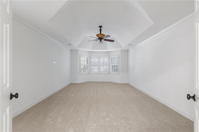 spare room with a raised ceiling, crown molding, ceiling fan, and light colored carpet