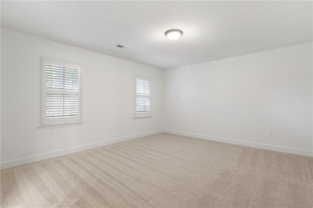 empty room with a healthy amount of sunlight and light carpet