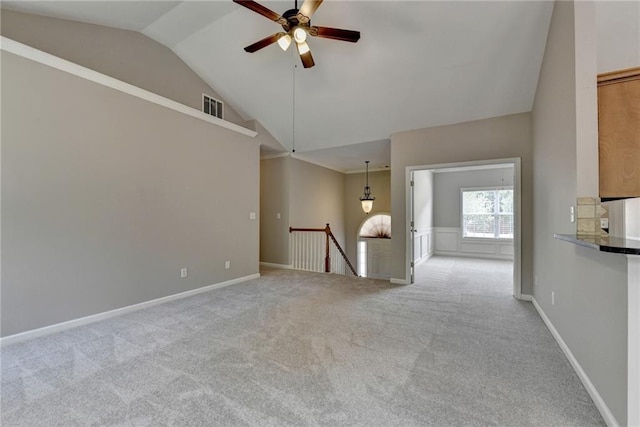 unfurnished living room featuring light carpet, vaulted ceiling, and ceiling fan