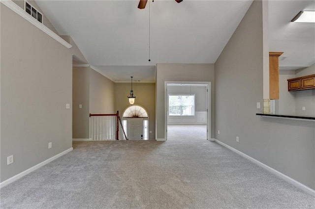 unfurnished living room with light colored carpet, vaulted ceiling, and ceiling fan