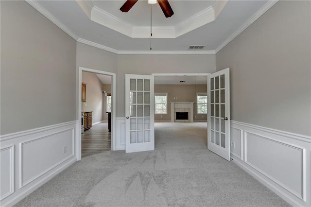 spare room featuring crown molding, light carpet, and french doors