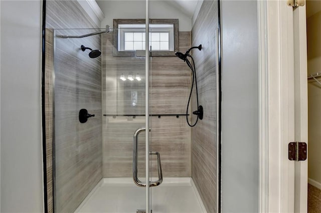 bathroom with lofted ceiling and a shower with shower door