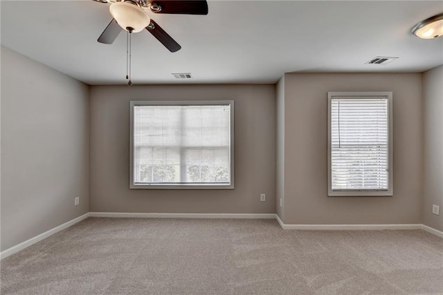 spare room featuring light carpet and ceiling fan