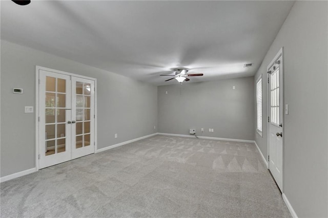 unfurnished room with light carpet, french doors, and ceiling fan