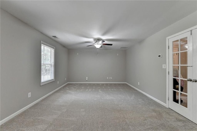 unfurnished room featuring ceiling fan, french doors, and light colored carpet