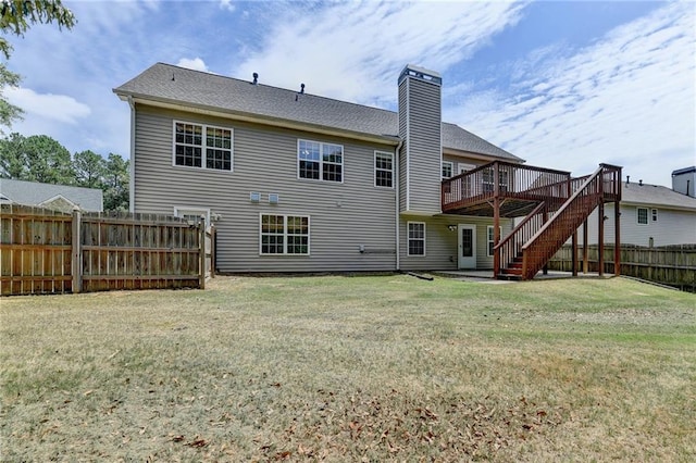 rear view of property with a lawn and a wooden deck