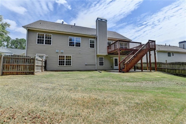 back of property with a lawn and a wooden deck