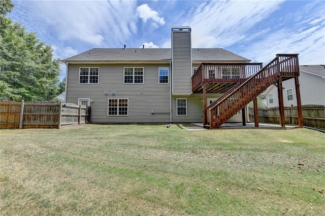 back of property with a lawn and a wooden deck