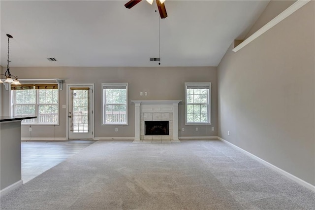 unfurnished living room with ceiling fan, light colored carpet, a fireplace, and high vaulted ceiling