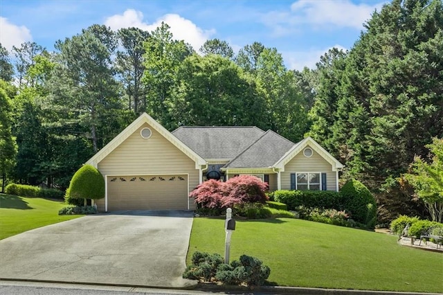 view of front of property with concrete driveway, an attached garage, and a front lawn