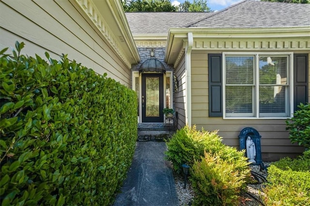 entrance to property with roof with shingles