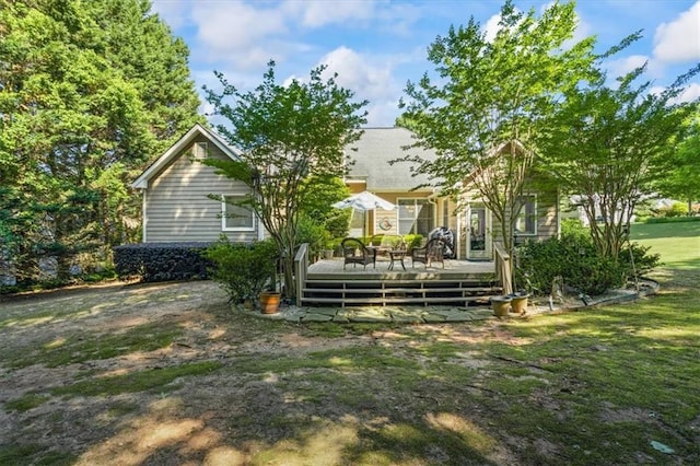 back of house with a wooden deck and a lawn