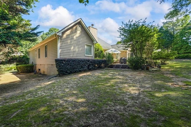view of home's exterior with a chimney and a deck