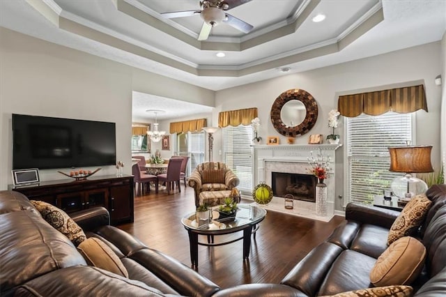 living area featuring ceiling fan, crown molding, healthy amount of natural light, hardwood / wood-style floors, and a chandelier