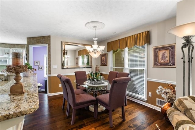 dining area featuring baseboards, a chandelier, a textured ceiling, and dark wood-type flooring