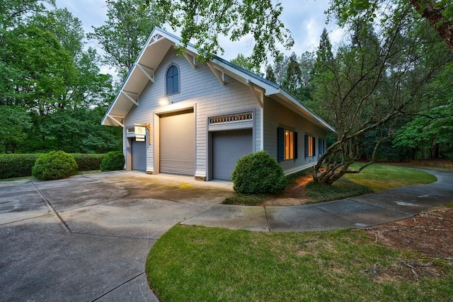 view of side of home featuring a garage and driveway