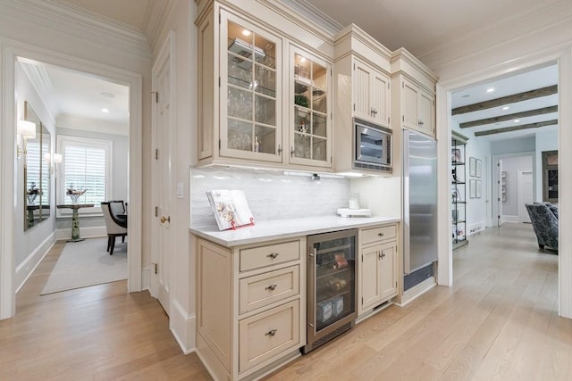 bar featuring beverage cooler, light wood finished floors, built in appliances, and backsplash