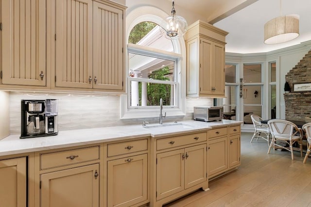 kitchen featuring a sink, light wood-style floors, and cream cabinetry
